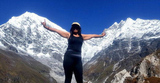Traveller celebrating in front of Himalayan peaks